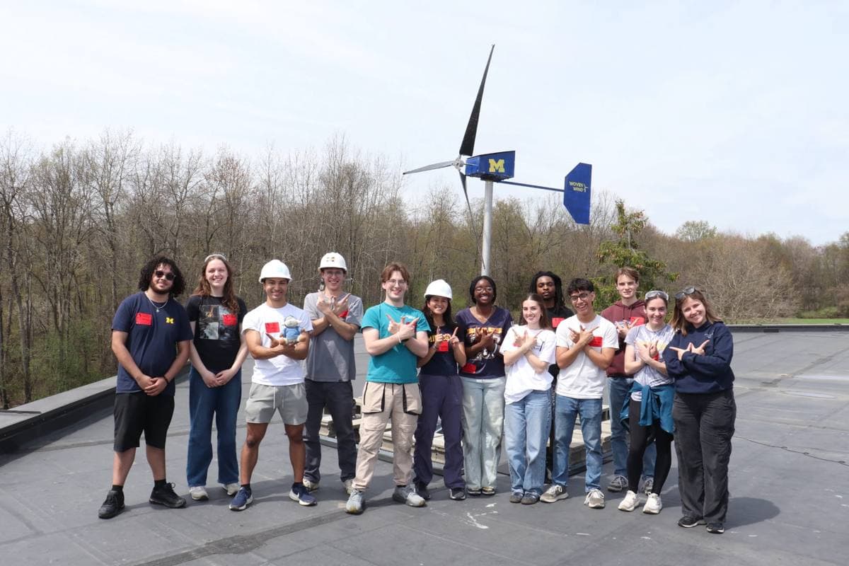 The Woven Wind team on a rooftop in front of our wind turbine